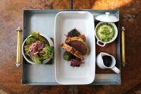 a tray with a plate of food with a sandwich and salad at The Goodwood Hotel in Chichester