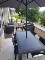 a table and chairs with an umbrella on a patio at Les terrasses de Malmédy in Malmedy