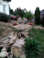 two statues of heads sitting on top of a rock at Traumparadies in Bad Sulza