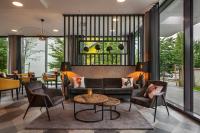 Una sala de estar con un sofá y sillas y una mesa. en Holiday Inn - the niu, Fury Aschheim Messe by IHG, en Aschheim