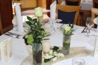 una mesa con jarrones llenos de flores y velas en Gasthaus Beinker, en Ostercappeln