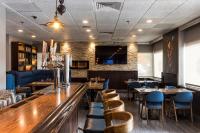 a restaurant with tables and chairs and a bar at Ottawa Embassy Hotel & Suites in Ottawa