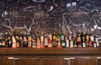 a bar with a wall with drawings of cows and alcohol at Ottawa Embassy Hotel & Suites in Ottawa