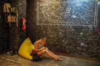 a woman sitting on the floor next to a tent at Wonderloft Hostel Kota Tua in Jakarta