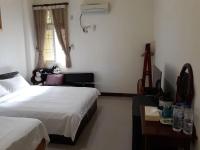 a bedroom with two beds and a table and a window at Star 101 Guest House in Taitung City