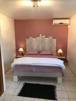 a bedroom with a large bed with pink pillows at Le repaire des Caraïbes in Trois-Rivières