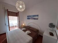 a bedroom with a bed and a fan and a window at a due passi dal mare in Diamante