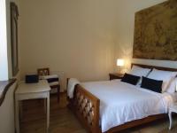 a bedroom with a large bed and a table and chair at La Merise Gite in Villefranche-dʼAlbigeois