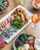 a table topped with plates of food with seafood at Huskisson Hotel in Huskisson