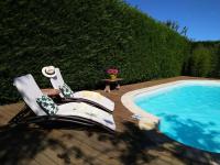 a deck with a chair next to a swimming pool at Les Bessonnes in Saint-Georges-Haute-Ville
