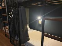 a bunk bed in a room with a light on it at Silom Space Hostel in Bangkok