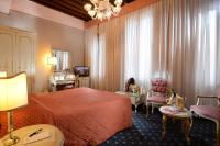 a hotel room with a red bed and a chair at Hotel Rialto in Venice