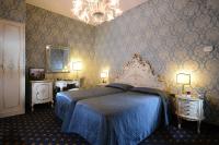a bedroom with a blue bed and a chandelier at Hotel Rialto in Venice