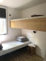 a small room with a bunk bed and a shelf at Mobil home PREMIUM 35m2 3 chambres 6 personnes in Arès