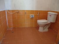 an orange tiled bathroom with a toilet and a shower at Malibu Beach Bungalows in Chaloklum