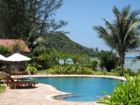 a swimming pool with a table and an umbrella at Malibu Beach Bungalows in Chaloklum