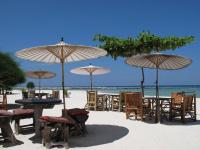 a group of tables and chairs on the beach with umbrellas at Malibu Beach Bungalows in Chaloklum