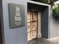 una señal en el lateral de un edificio con una puerta de madera en The Tree House Boutique Hotel by The Living Journey Collection, en Ciudad del Cabo