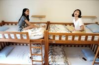 two girls sitting on bunk beds in a room at Backpacker 41 Hostel - Kaohsiung in Kaohsiung