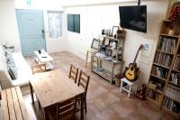 a living room with a table and a guitar at Backpacker 41 Hostel - Kaohsiung in Kaohsiung