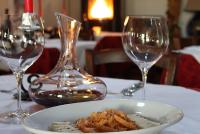 a plate of food on a table with two wine glasses at Ristorante Alloggio Ostello Amolara in Adria
