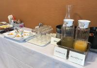 函馆Credo Hotel Hakodate的一张桌子上摆放着自助餐食物和瓶装果汁。