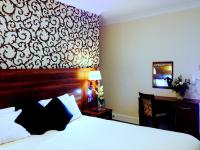 una habitación de hotel con una cama y un escritorio en Ely House Hotel, en Wolverhampton