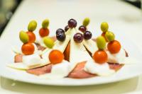 a plate of food with grapes and fruit on it at Hotel Oasis in Podgorica