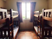 a room with three bunk beds and a window at Backpacker 41 Hostel - Kaohsiung in Kaohsiung