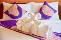 two swans towels on a tray on a bed at Sivalai Place in Bangkok