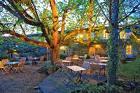 a group of tables and chairs under a tree at Hotel La Maison des Peyrat in Sarlat-la-Canéda