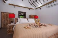 a bedroom with a bed with two swans on it at Rinjani Lodge in Senaru