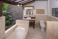 a bathroom with a tub and a toilet and a sink at Rinjani Lodge in Senaru