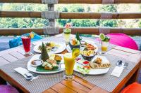 a table with plates of food and drinks on it at Rinjani Lodge in Senaru