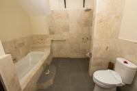 a bathroom with a toilet and a tub and a sink at Rinjani Lodge in Senaru