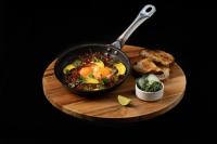 a pan of food on a wooden plate with bread at Socialtel Parque 93 Bogota in Bogotá