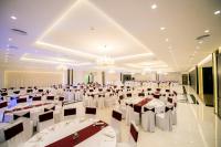 a banquet hall with white tables and chairs and chandeliers at Holiday Resort in Velika Slatina
