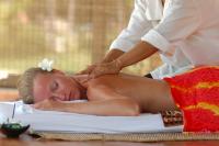 a woman getting a back massage on a book at Sarikantang Resort & Spa, Koh Phangan in Haad Rin