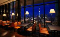 a restaurant with tables and chairs and a view of the city at The Gate Hotel Kaminarimon by Hulic in Tokyo