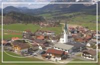 a small town with a church and a mountain at Alpen Chalet ELLMAU Zentrum in Ellmau