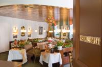 Un comedor con mesas y sillas y un restaurante. en Hotel Burg Bollendorf, en Bollendorf