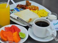 a table with two plates of food and a cup of coffee at Jesens Inn II in Kuta