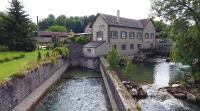 a house and a river next to a building at Moulin de Chappes in Chappes