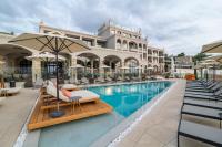 una piscina en un hotel con sillas y sombrillas en Villa Chinka by Astor Garden Hotel - Adults Only, en Saints Constantine and Helena