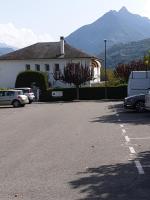 a parking lot with cars parked in front of a building at appartement Isabelle in Lau-Balagnas