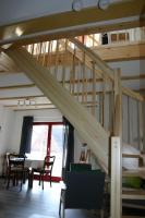 a wooden staircase in a room with a table and chairs at Apartment Jakobsweg GbR in Pettstädt