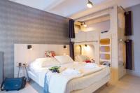a bedroom with a large white bed and bunk beds at Hôtel Club mmv Le Flaine *** in Flaine