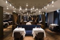 地拉那Maritim Hotel Plaza Tirana的餐厅设有2张带白色桌布的桌子