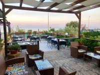 een restaurant met tafels en stoelen op een terras bij Hotel Jonio in Noto Marina