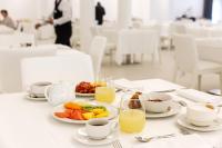a table with plates of food and cups of orange juice at Toscana Charme Resort in Tirrenia
